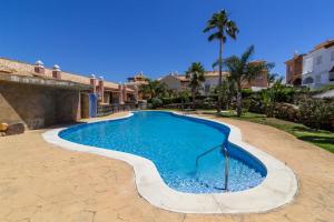 a swimming pool in a yard with a house at Zahara Sol Villas y Apartamentos by QHotels in Zahara de los Atunes