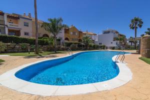 a swimming pool in a yard with a building at Zahara Sol Villas y Apartamentos by QHotels in Zahara de los Atunes
