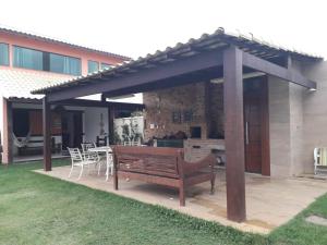 a wooden bench under a pergola on a patio at Casa Duas Torres in Búzios
