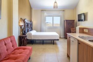 a living room with a bed and a kitchen at Zahara Sol Villas y Apartamentos by QHotels in Zahara de los Atunes