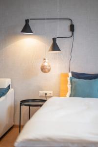 a bedroom with a bed and two lights and a table at Apartments Leopold Ferdinand in Sankt Stefan im Lavanttal