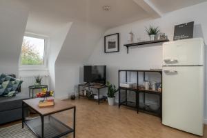 a living room with a refrigerator and a tv at CASSEL LOFTS - Gemütliches Apartment für 3 - Nähe Marienkrankenhaus in Kassel