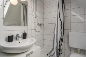 a white bathroom with a sink and a shower at CASSEL LOFTS - Gemütliches Apartment für 3 - Nähe Marienkrankenhaus in Kassel