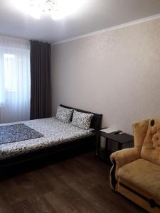 ヘルソンにあるApartment - Nebesnoi Sotni Streetのベッドルーム1室(ベッド1台、椅子付)