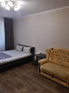 ヘルソンにあるApartment - Nebesnoi Sotni Streetのベッドルーム(ソファ、ベッド、椅子付)