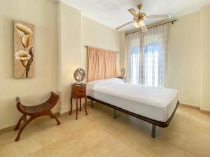 a bedroom with a bed and a chair and a window at Zahara Sol Villas y Apartamentos by QHotels in Zahara de los Atunes
