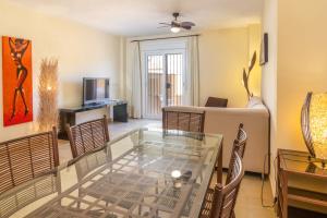 a living room with a glass table and chairs at Zahara Sol Villas y Apartamentos by QHotels in Zahara de los Atunes