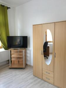 a room with a television and a cabinet with a mirror at Wohnen in 09599 Freiberg, Buchstraße 14 in Freiberg