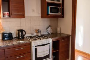 a kitchen with a stove and a microwave at Piso 9 Vista panorámica a la ciudad in La Plata