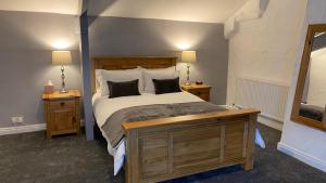 1 dormitorio con 1 cama con 2 mesitas de noche y 2 lámparas en Bridge Farm Hotel, en Leeds