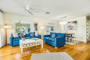 a living room with blue couches and a table at Sandy's Getaway in Anna Maria