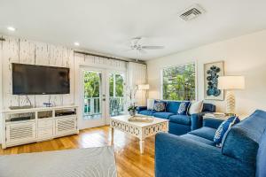 a living room with blue couches and a tv at Sandy's Getaway in Anna Maria