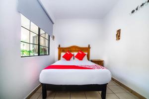 a bedroom with a bed with red pillows on it at Casa Banqueta Alta in Guanajuato