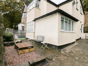 a house with chairs and a bench in front of it at Coppice Hollow in Buxton