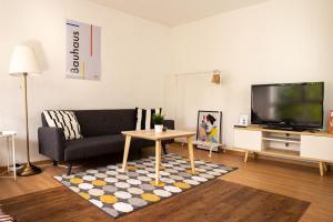 salon z kanapą i stołem w obiekcie FULL HOUSE Studios - KornhausDeluxe Apartment - Balkon, WiFi w mieście Dessau