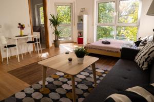 a living room with a couch and a table at FULL HOUSE Studios - KornhausDeluxe Apartment - Balkon, WiFi in Dessau