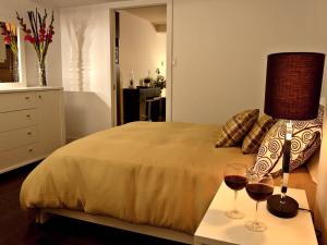 1 dormitorio con 1 cama y 2 copas de vino en Les Immeubles Charlevoix - Le 1176, en Quebec