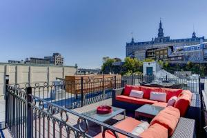 a balcony with a couch and tables on a building at Les Immeubles Charlevoix - Le 1176 in Quebec City