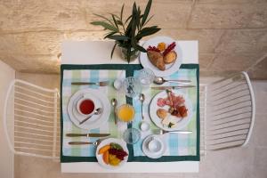 una mesa con platos de comida y bebidas. en Amatè Suite, en Lecce