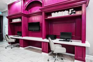 a pink room with two desks and two monitors at Hotel Indigo Dallas Downtown, an IHG Hotel in Dallas