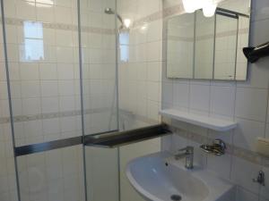 La salle de bains est pourvue d'un lavabo et d'un miroir. dans l'établissement Vacation home Zwaantje #DKR2, à Callantsoog