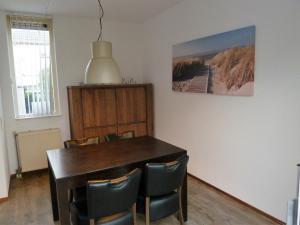 een eetkamer met een tafel en stoelen bij Vacation home Zwaantje #DKR2 in Callantsoog