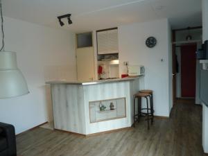een keuken met een aanrecht en een bar in een kamer bij Vacation home Zwaantje #DKR2 in Callantsoog