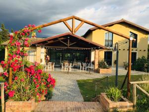 a house with a patio with red flowers at Country House Erba Regina in Frascati