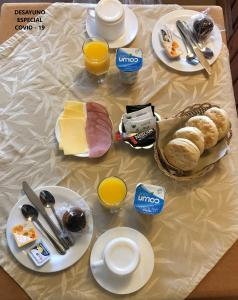 une table recouverte de assiettes de nourriture et de jus d'orange dans l'établissement Hotel Luanco, à Temuco