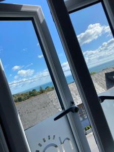 a window with a view of the ocean at Waves - Duplex Apartment Stoke Fleming in Stoke Fleming