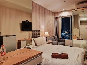 um quarto de hotel com uma cama e uma sala de estar em Apartemen grand kamala lagoon by 21 Room em Bekasi