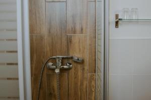 eine Dusche im Bad mit einer Holztür in der Unterkunft Pension Tofalvi in Harghita-Băi