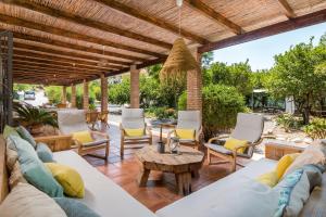 un patio con sofá, sillas y mesa en Finca Limón en Pizarra