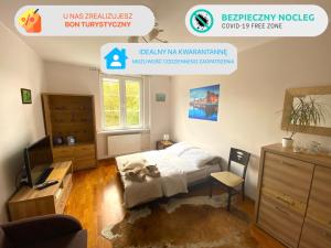 a bedroom with a bed and a desk and a tv at Gdańskie Apartamenty - Apartment Superior in Old Town in Gdańsk