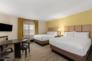 a hotel room with two beds and a desk at Candlewood Suites - Fairbanks by IHG in Fairbanks +67 photos