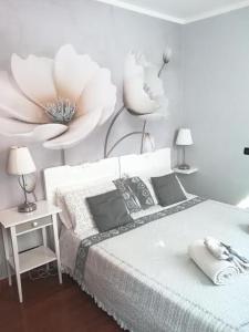 a white bedroom with a bed and two lamps on the wall at Appartamento Ca' Marco Polo in Venice