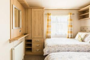 una piccola camera da letto con due letti e una finestra di Thumper Lodge - Luxury lodge with Hot Tub a South Cerney Altre 49 foto