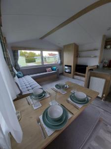einen Tisch mit Tellern darauf im Wohnzimmer in der Unterkunft Woofles Luxury Caravan at Knaresborough Lido in Knaresborough