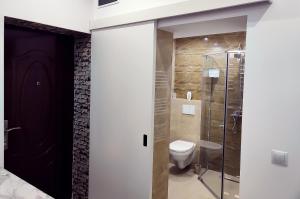 een badkamer met een toilet en een glazen douche bij Stefan Center Apartment in Sibiu