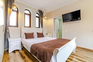 una camera con letto e TV a schermo piatto di Yael Luxury Apartments 2 a Buşteni