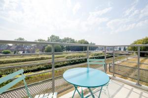 a balcony with a blue table and chairs at Nice studios fully equipped near SHAPE area in Mons
