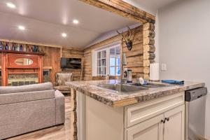 uma cozinha com um lavatório e uma sala de estar em Rustic Anchorage Hideaway Walk to Coastal Trail! em Anchorage