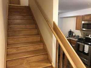 eine Treppe in einer Küche mit Holztreppe in einem Haus in der Unterkunft The Woods Inn in Inlet