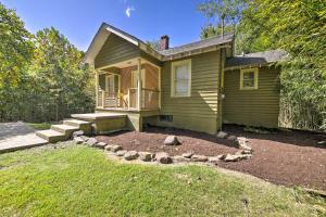 a small green house with a porch and a yard at Pet-Friendly Cottage with Fire Pit - 3 Mi to SIU! in Carbondale