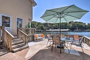 a patio with a table and an umbrella at On-the-Water Retreat with Dock Pet Friendly! in Lake Ozark