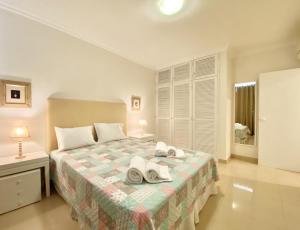 1 dormitorio con 1 cama con toallas en Tália XI - Near the beach - Vilamoura en Vilamoura
