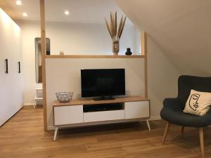 a living room with a flat screen tv on a entertainment center at Ferienwohnung Siedlungsnest in Anklam