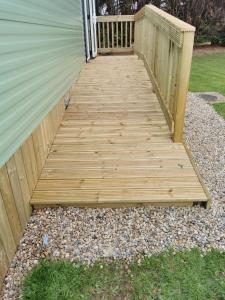 a wooden walkway leading up to a house at Rustling Pines at Knaresborough Lido in Harrogate