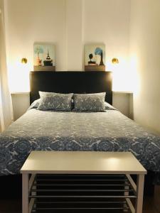 Dormitorio con cama con banco en Casa Bajo la Roca, en Setenil
