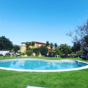 een zwembad in het gras met een gebouw op de achtergrond bij Bed & Breakfast Il Rosmarino in Bosa